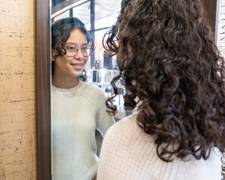 Client trying on glasses during eyewear styling consultation at Sweet View Optical Sugar Hill GA