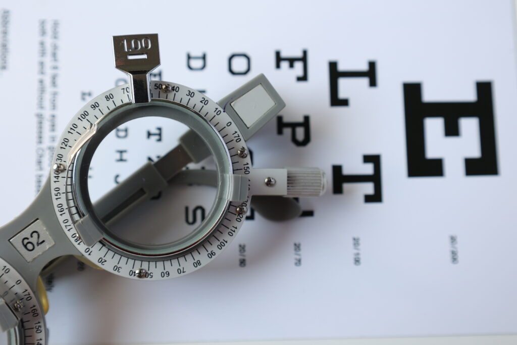 Hyperopia measurement tool placed on top of an eye chart, showcasing precision equipment used for vision testing