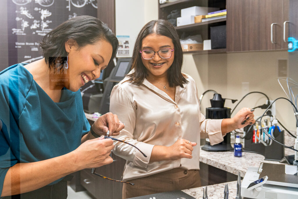 Woman crafting luxury eyeglass frames in an in-house lab, focused on precision and craftsmanship in a sophisticated, well-equipped workspace.